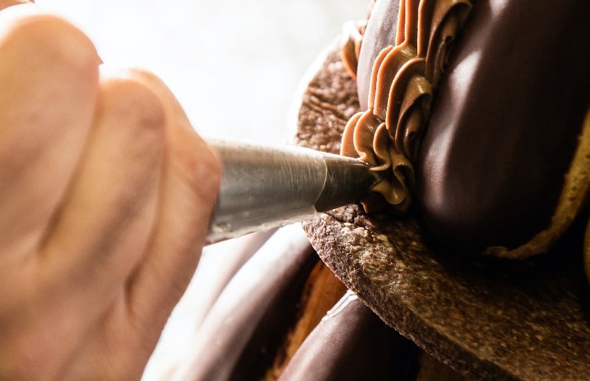 Een chocoladetaart decoreren met een gecanneleerde spuitzak