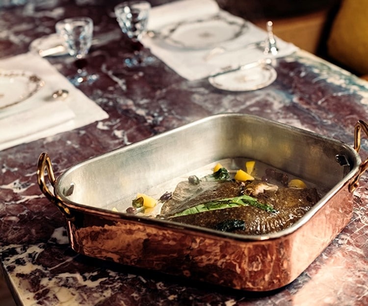 Turbotière and turbot served at the table