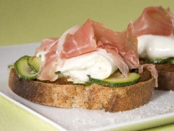Tartine grillée à l'ail au jambon fumé, courgettes et mozzarell