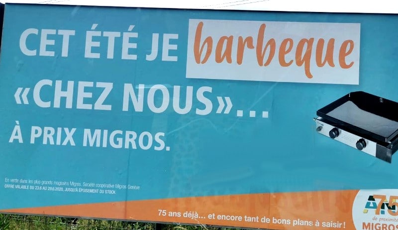 Cartelera publicitaria en un supermercado suizo con el verbo "barbequer"