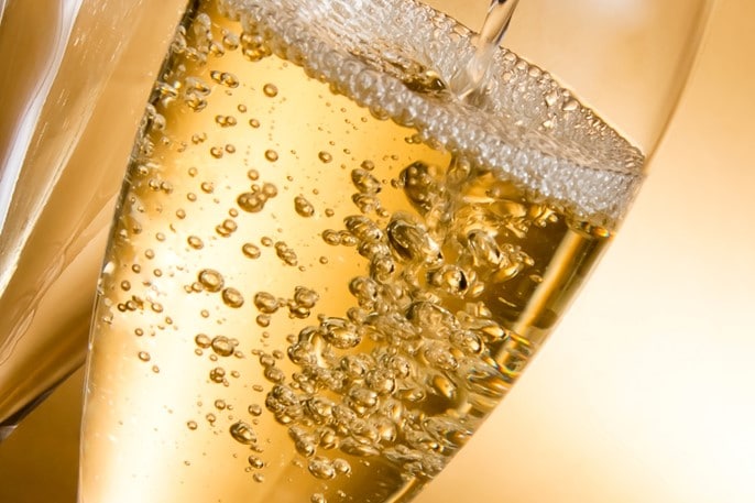 Bubbels en schuim uit een champagnefluit
