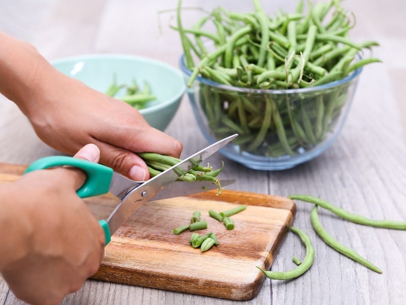 はさみで豆から茎を取り除きます